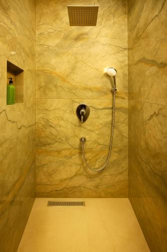 a bathroom with a shower with a hose on the wall at Lal Cottage in Jaipur