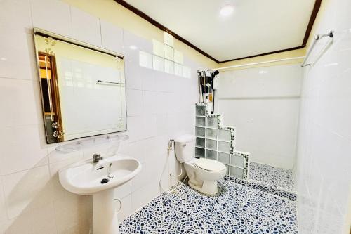 Un baño blanco con inodoro y lavabo. en Paradise Resort Buriram, en Buriram