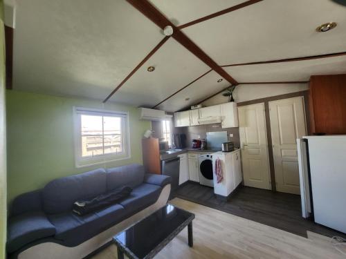 un salon avec un canapé et une cuisine dans l'établissement Camping Les Embruns N7, au Grau-dʼAgde
