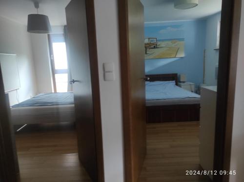 a room with a bedroom with a bed and a mirror at Apartament Nadmorski w Jastarni in Jastarnia