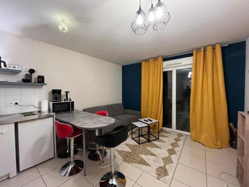 une cuisine et un salon avec une table et des chaises dans l'établissement Studio Spacieux à Montpellier - Terrasse & Netflix, à Montpellier