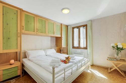 a bedroom with a large white bed with green cabinets at Casa Andy 1 Val Lavizzara - Happy Rentals in Al Piano
