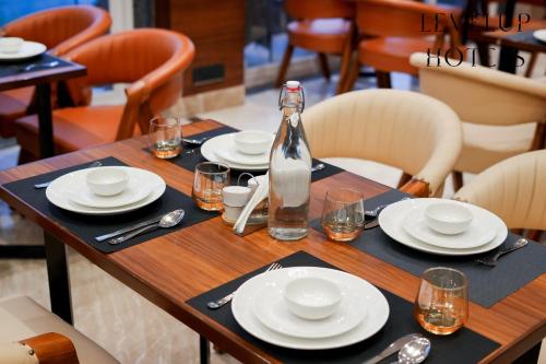 a wooden table with plates and a bottle on it at Levelup Signature Divine Peaks in Jāmb