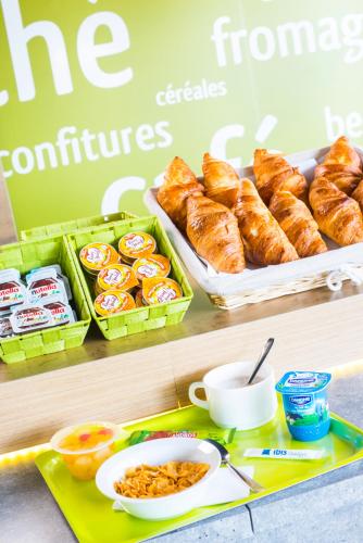 a table with a tray of pastries and other food at ibis budget Marne la Vallée Bry sur Marne in Bry-sur-Marne