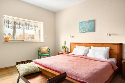 a bedroom with a bed and two chairs and a window at Nahariya Beachside Comfort Stay by Sea N Rent in Nahariyya