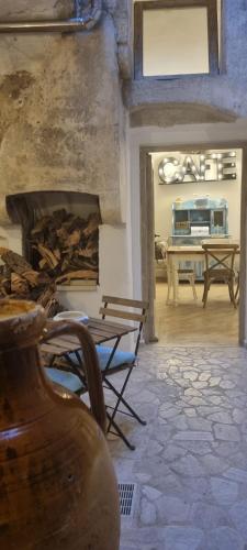 Una sala de estar con chimenea y una mesa. en Casa Fondaco, en Gallipoli