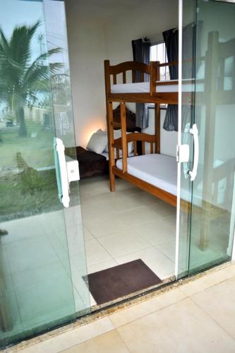 a room with two bunk beds and a glass door at Iris Pousada Hostel Arraial do Cabo in Arraial do Cabo