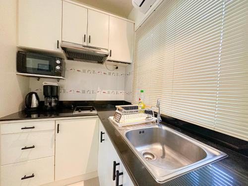 a kitchen with a stainless steel sink and a window at Oasis 1 Bedroom Apartment In Rawai in Phuket Town