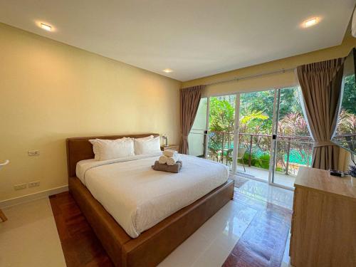 a bedroom with a bed with a teddy bear on it at Oasis 1 Bedroom Apartment In Rawai in Phuket Town