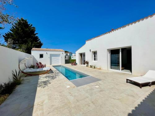 une cour arrière avec une piscine et une maison dans l'établissement 900-D La Chaumillonière - Modernity, comfort and pool, au Bois-Plage-en-Ré