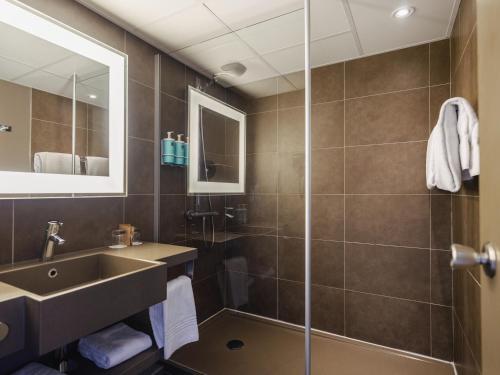 a bathroom with a sink and a shower at Novotel Nantes Centre Gare in Nantes
