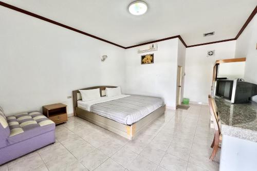 a bedroom with a bed and a couch and a tv at Paradise Resort Buriram in Buriram