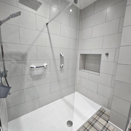 a bathroom with a shower with a glass door at Beach Court Holiday Apartments in Skegness