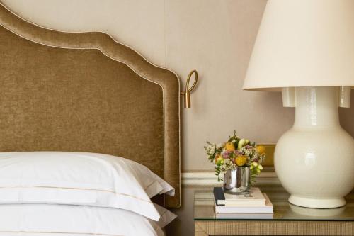 a bedroom with a bed and a table with a lamp at Egerton House in London