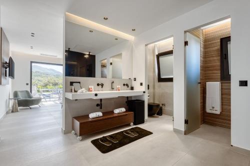 ein Badezimmer mit Waschbecken und Spiegel in der Unterkunft Villa Serenissima by PosarelliVillas in Acharavi