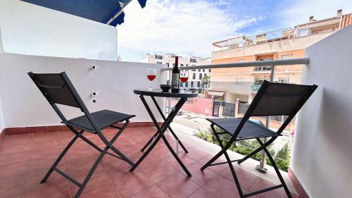 a balcony with two chairs and a table with wine glasses at Mirador de Gema in Torrox Costa