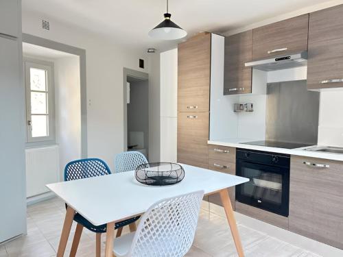- une cuisine avec une table et des chaises blanches dans l'établissement Chambre 2 personnes FLIP Parthenay - Maison avec 2 chb - 1 sde partagée, à Parthenay
