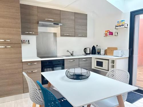 - une cuisine avec une table et des chaises blanches dans l'établissement Chambre 2 personnes FLIP Parthenay - Maison avec 2 chb - 1 sde partagée, à Parthenay