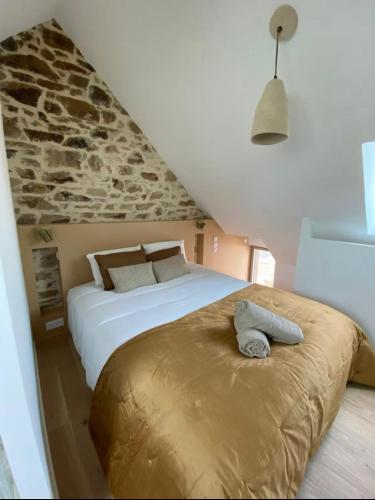 une chambre avec deux lits et un mur en pierre dans l'établissement la maison Albanaise, à Saint-Alban