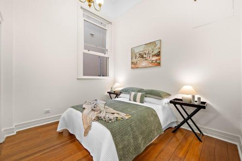 a white bedroom with a bed and a window at Ultimate Fremantle Location in Fremantle