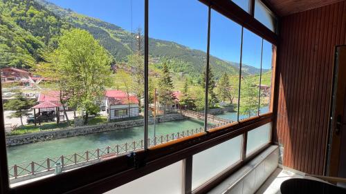 a window with a view of a river and mountains at Lavera Home Uzungöl in Uzungöl