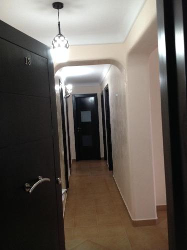 a hallway with a black door and a hallway leading into a room at Bel appartement, vue imprenable sur la mer, 80 m2, et super terrasse in Marina Smir