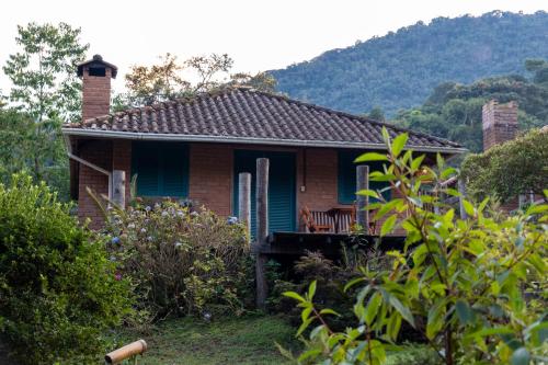 a small house with a porch and a bench at Estalagem Engenho de Serra - Parque Nacional do Itatiaia - Parte Alta in Itamonte