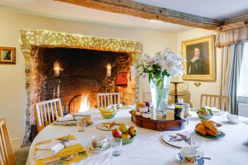 a dining room with a table with a fireplace at Hollamoor Farm in Barnstaple