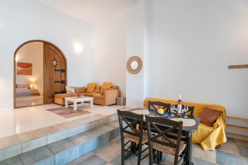 a living room with a table and a couch at Maggano Paros Apartments 2 in Angairiá