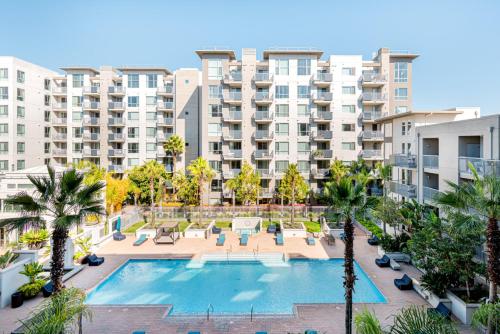 an apartment complex with a swimming pool and palm trees at Blueground Santa Clara 2bd apartment SFO-1771 in Milpitas