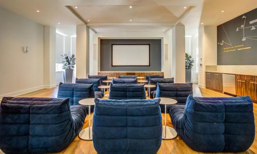 a lecture room with blue chairs and a screen at Blueground Santa Clara 2bd apartment SFO-1771 in Milpitas