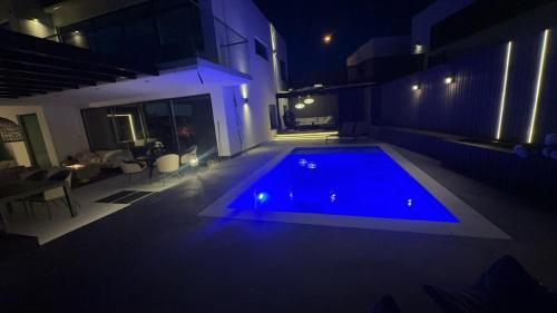 a large swimming pool in a house at night at Luxury Villa with Heated Pool & Sea View Your Private Paradise on the Norwegian Coast in Kristiansand