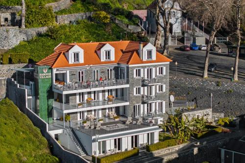 a large house with an orange roof on top of it at OurMadeira - Babosas Village in Funchal