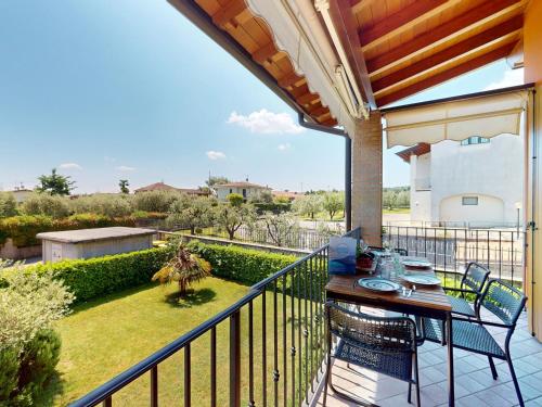 a patio with a table and chairs on a balcony at Adeline Garda Nest by Bookinggardalake in Raffa