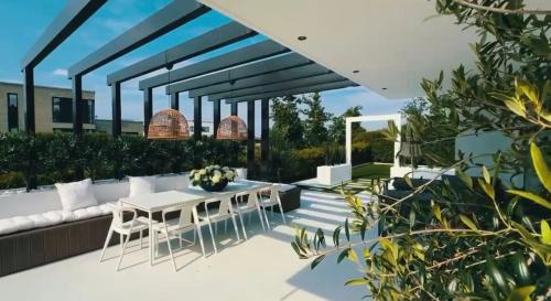 a patio with a white table and chairs at Luxury Villa with Heated Pool & Sea View Your Private Paradise on the Norwegian Coast in Kristiansand