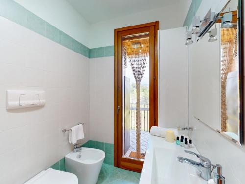 a bathroom with a tub and a toilet and a window at Adeline Garda Nest by Bookinggardalake in Raffa