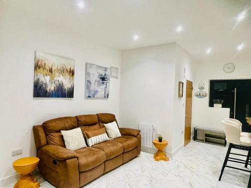 a living room with a brown couch in a room at Brand-New Modern 2 Bed Room Apart ment With FREE Parking in Plymouth