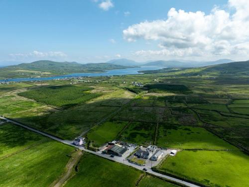 an aerial view of a field with a body of water at Skellig View Kerry Cliffs View Balcony Room in Portmagee