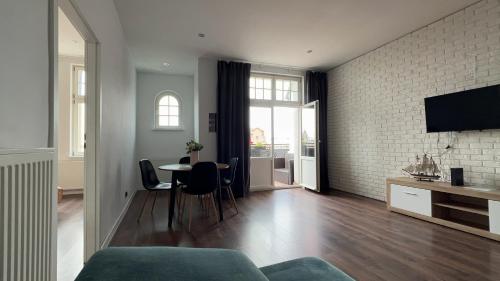 a living room with a couch and a table with chairs at Long Island in Grudziądz