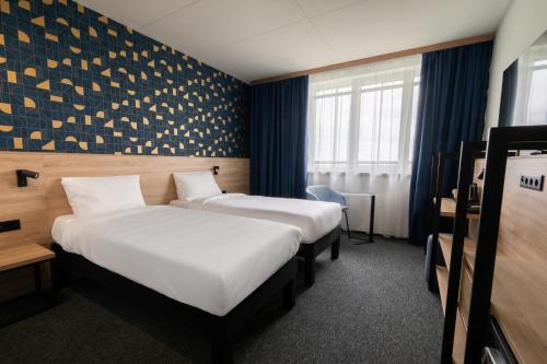 a hotel room with two beds and a window at ibis Styles Debrecen Airport in Debrecen