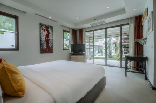 Ban Thalat Choeng ThaleにあるLuxury 3BR Villa, Private Pool, Gym & Jacuzziの大きな白いベッドとテレビのある寝室