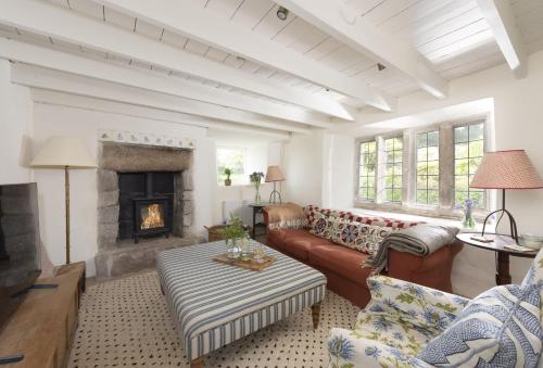 a living room with a couch and a fireplace at Besloe in Delabole
