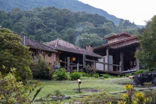 a house with a mountain in the background at Estalagem Engenho de Serra - Parque Nacional do Itatiaia - Parte Alta in Itamonte