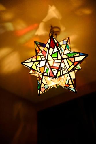 a colorful star light hanging from a ceiling at Hotel Unica in Biei