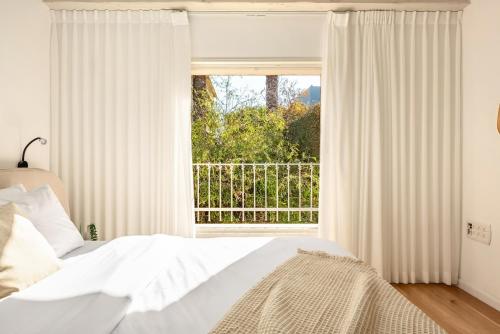 a bedroom with a bed and a large window at The Stone Age Palace with Mamad by Sea N Rent in Caesarea