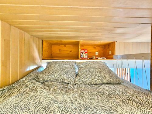 un lit dans une chambre avec un plafond en bois dans l'établissement Appartement Cosy 600m de la plage, à Fouesnant