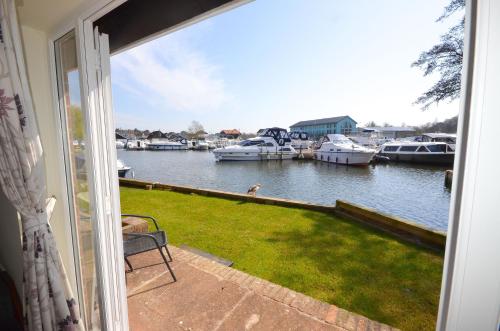 a balcony with a view of a marina with boats at Cavell - sleeps 2 people right in the heart of Wroxham on the Norfolk Broads in Wroxham