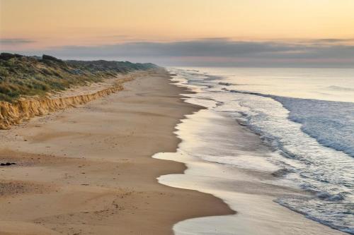 a view of a beach with waves coming in at Honeysuckles Ultimate Beach Escape in Seaspray