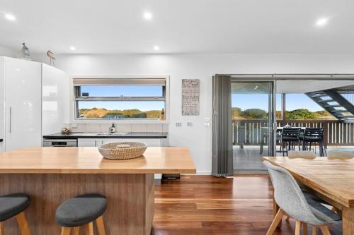 a kitchen and dining room with a table and chairs at Honeysuckles Ultimate Beach Escape in Seaspray