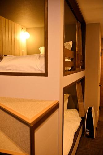 a small room with a bed and a mirror at Hotel Unica in Biei